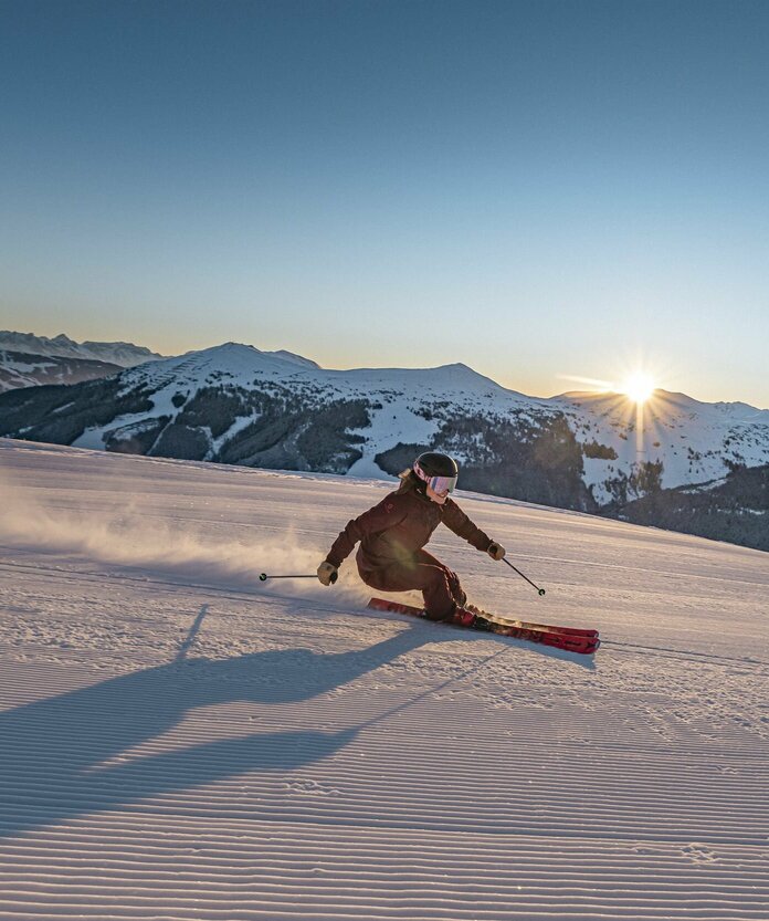 Skifahrer vor untergehender Sonne
