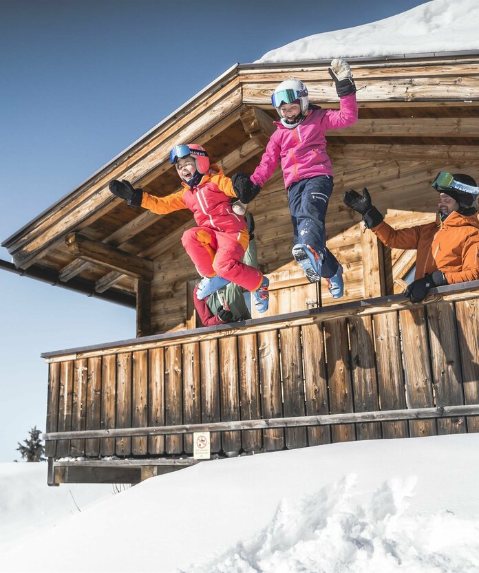 Familie in Skiausrüstung auf Berghütte