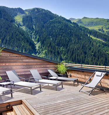 Sonnenliegen auf Dachterrasse mit Panoramaausblick auf Berge